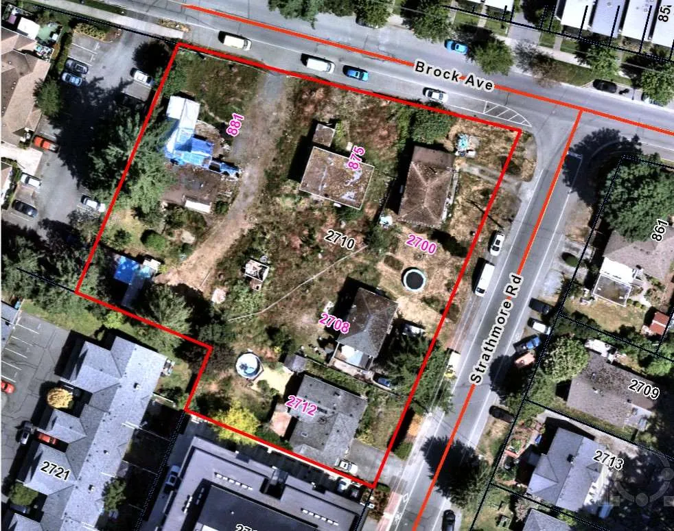 Property photo showing boarded building, perimeter debris and graffiti at 2710 Strathmore Road