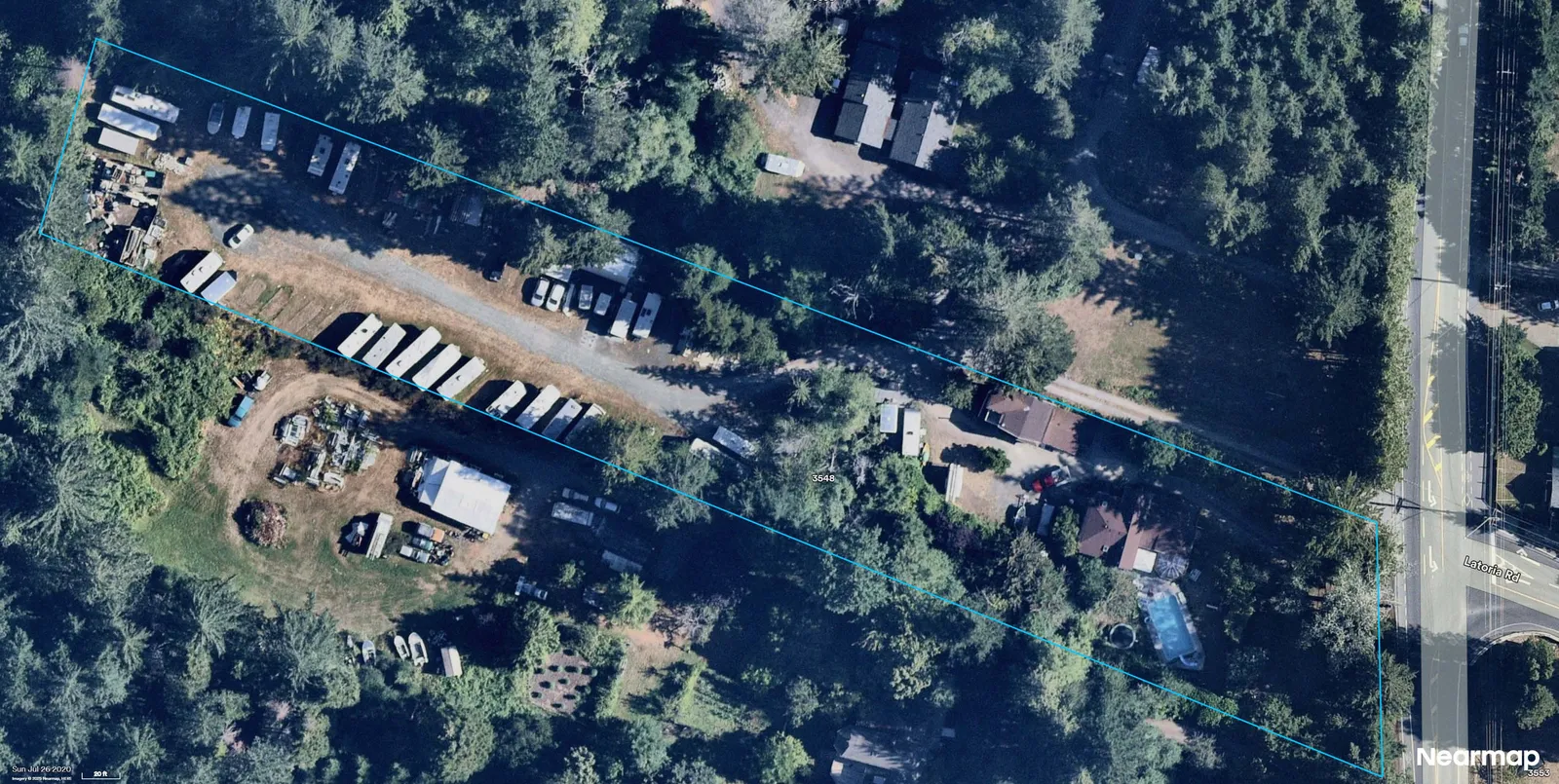 Aerial photograph showing a long narrow parcel outlined in blue with multiple trailers/RVs parked along a central gravel drive; a residence with pool near the right edge adjacent to Latoria Rd; property identifier "3548" visible on the parcel.