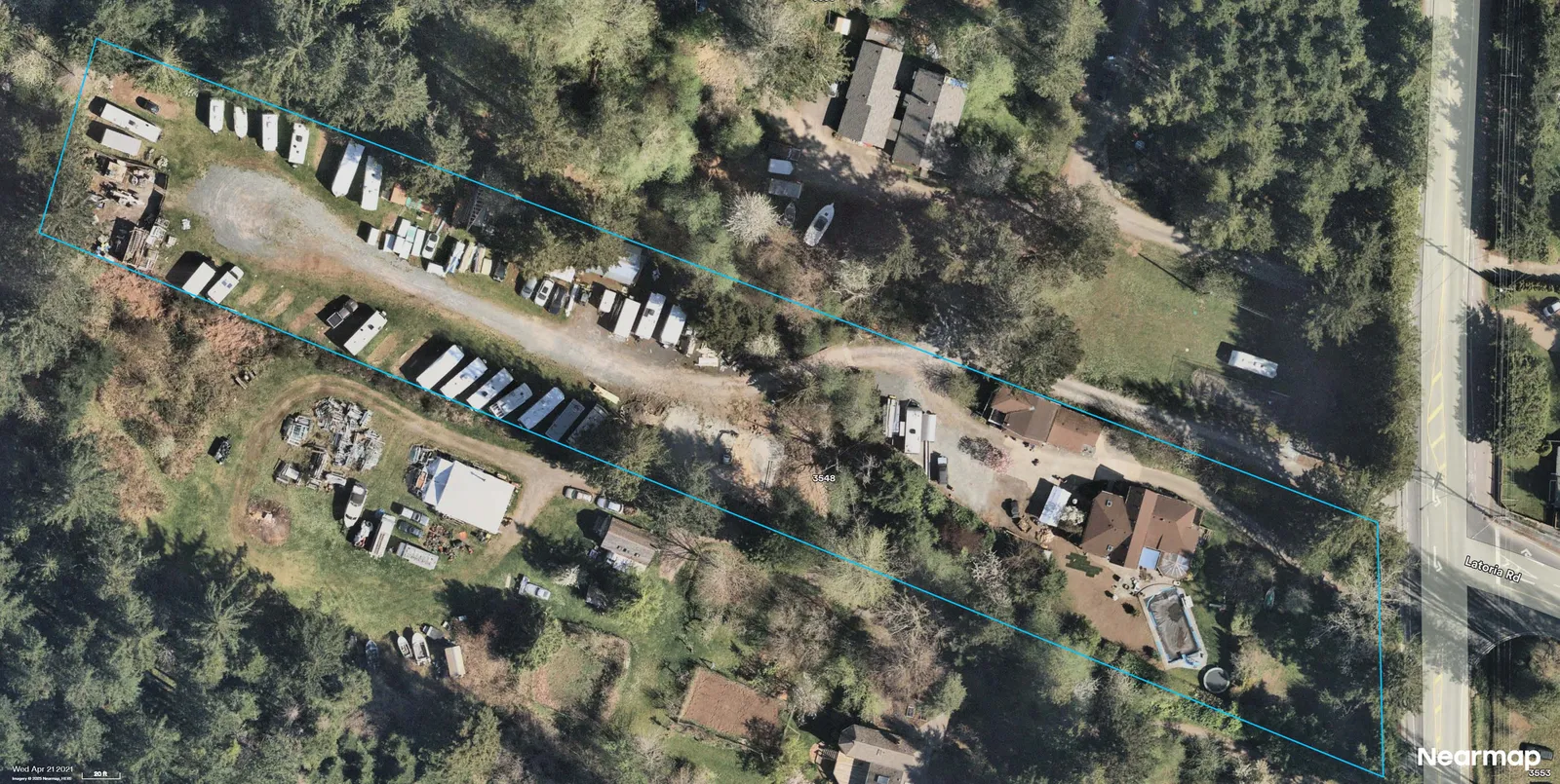 Aerial photograph showing the same parcel outlined in blue with trailers/RVs parked along the central drive; residence and pool visible near the right edge adjacent to Latoria Rd; clear view of open areas and storage yards.