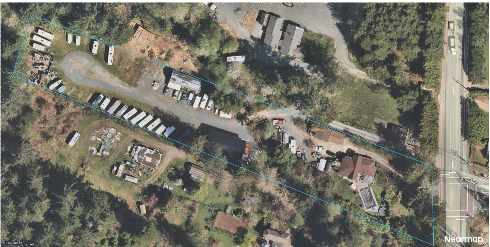 Aerial photograph showing the parcel outlined in blue with a large building in the western portion and multiple trailers/RVs aligned along the central drive; residence and pool near the right edge adjacent to Latoria Rd; nearby parcels and access drives visible.