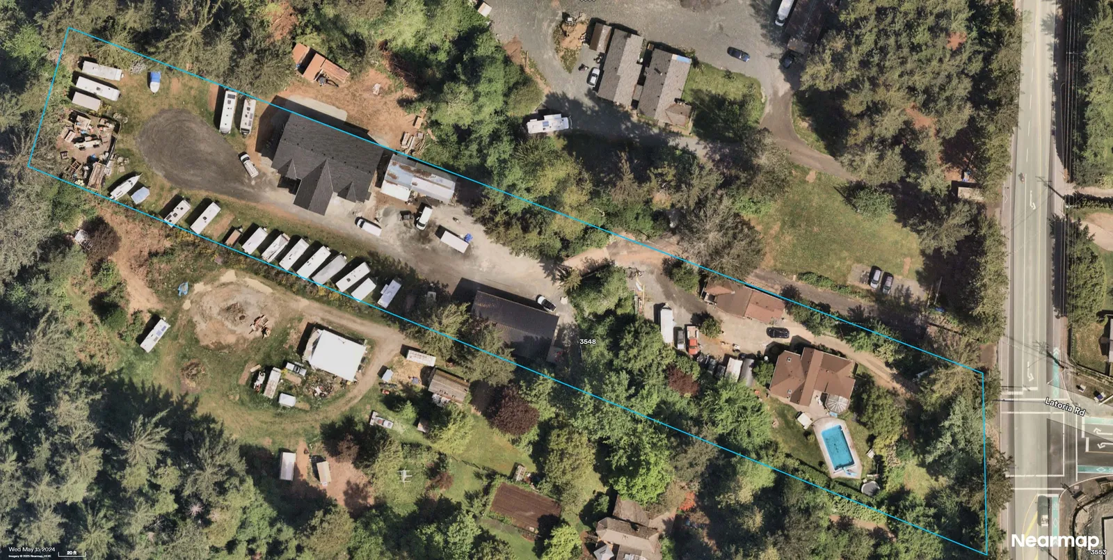 Aerial photograph showing the parcel outlined in blue with a large building in the western portion, trailers/RVs and storage along the central drive, and the residence with pool near Latoria Rd; site changes and organization of vehicles/storage compared with prior years visible.