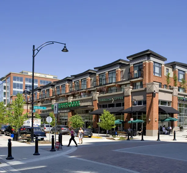 Commercial frontages and seating along a sidewalk.